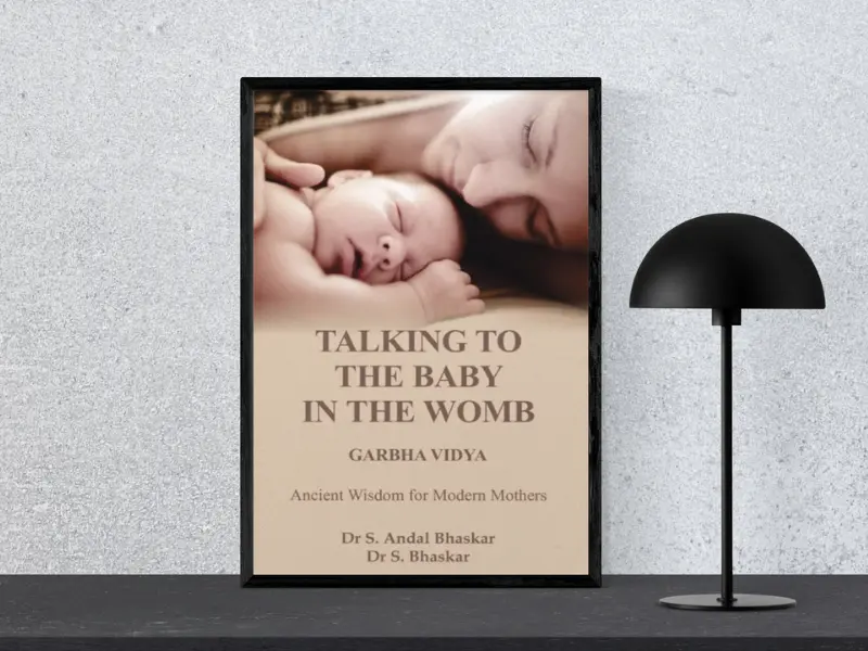 Talking to the Baby in the Womb — Garbha Vidya Book cover of "Talking to the Baby in the Womb — Garbha Vidya" by Dr S Andal Bhaskar, placed in a black frame beside a modern black lamp.