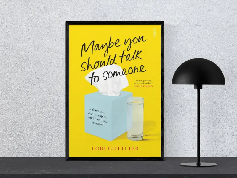 Maybe You Should Talk to Someone by Lori Gottlieb Book cover of Maybe You Should Talk to Someone by Lori Gottlieb, featuring the subtitle ‘Tiny Changes Remarkable Results’, displayed in a black frame next to a modern black lamp, highlighting