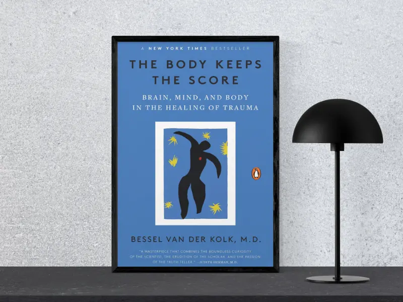 The Body Keeps the Score by Bessel Van Der Kolk, M.D. Book cover of The Body Keeps the Score: Brain, Mind, and Body in the Healing of Trauma by Bessel van der Kolk, featuring the subtitle ‘Tiny Changes Remarkable Results’, displayed in a black frame next to a modern black lamp, highlighting, good books on mental health