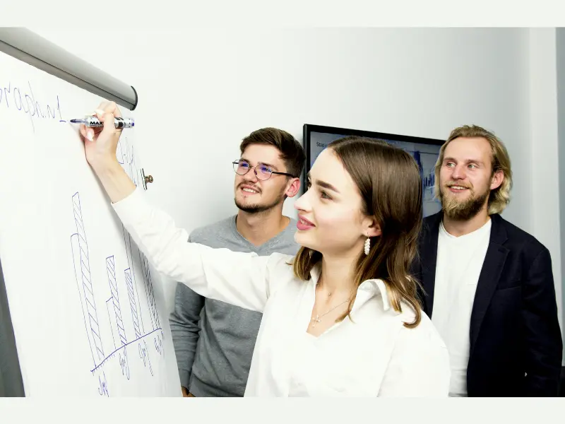 Team discussing and drawing financial growth charts similar to concepts from the Coffee Can Investing book