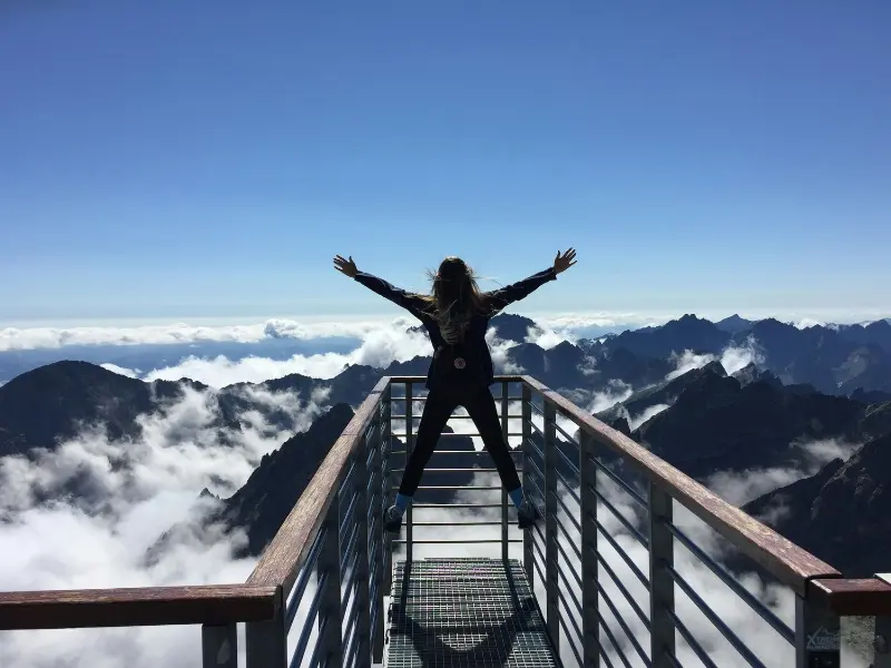 A girl is exploring new things. sky is blue and moutain is in the picture. it shows she leads a happy life